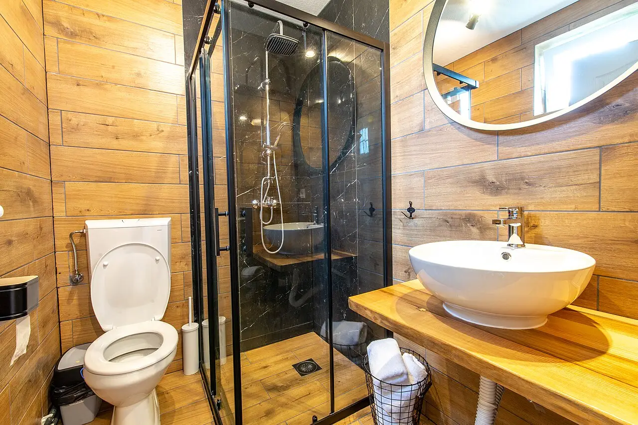 Une salle de bain refaite, douche vitrée et meuble en bois